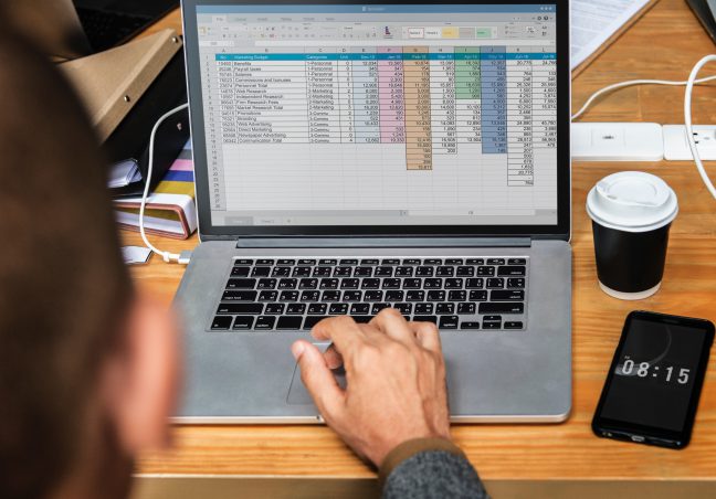 laptop on table with excel sheet on screen